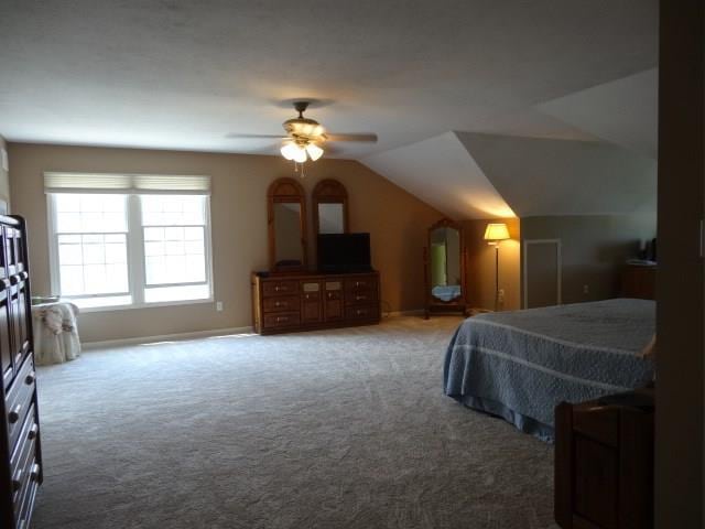 bedroom with ceiling fan, carpet flooring, and vaulted ceiling