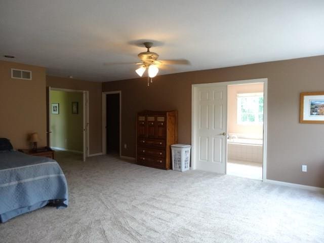 carpeted bedroom featuring ceiling fan and ensuite bath