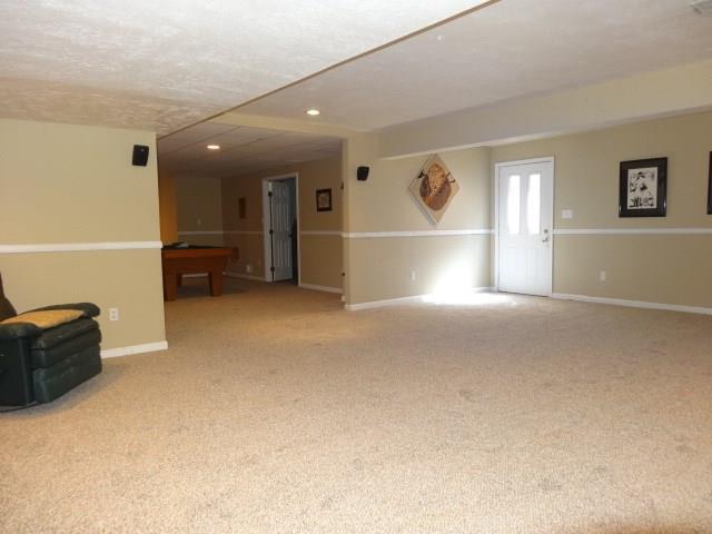 carpeted empty room featuring a textured ceiling and pool table