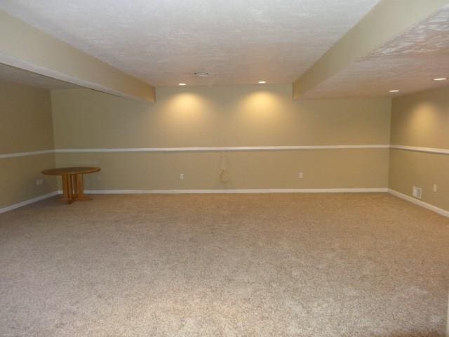 carpeted empty room featuring a textured ceiling