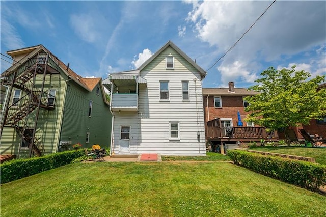 back of property with a wooden deck and a lawn