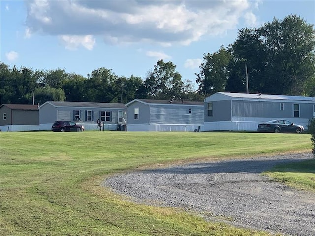 back of house with a yard and an outdoor structure