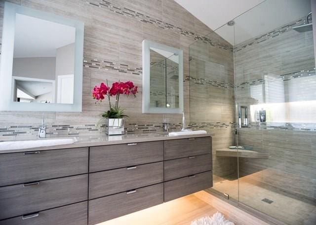 bathroom with tile walls, an enclosed shower, double sink vanity, and lofted ceiling