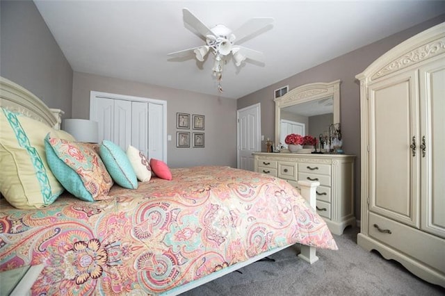 bedroom with a closet, light colored carpet, and ceiling fan