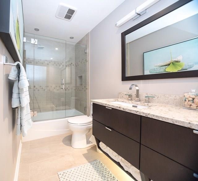 full bathroom with tile flooring, toilet, enclosed tub / shower combo, and vanity with extensive cabinet space