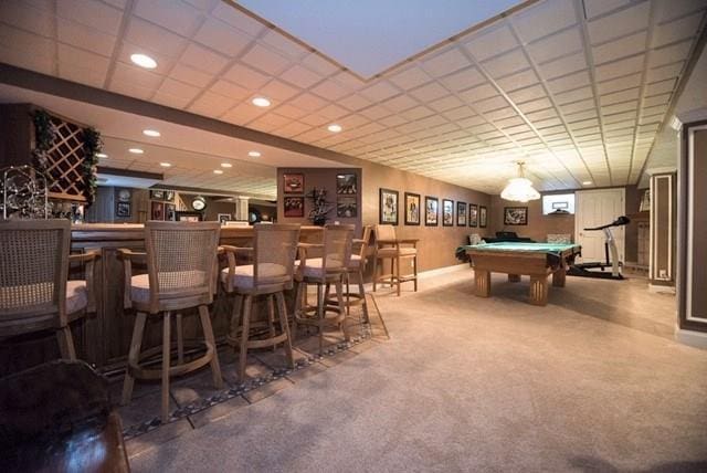 game room featuring a drop ceiling, pool table, carpet, and indoor bar