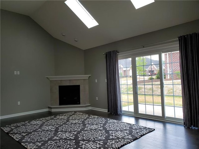 unfurnished living room with lofted ceiling with skylight and dark hardwood / wood-style flooring