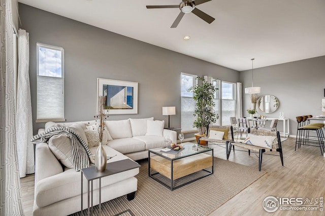 living room featuring light hardwood / wood-style flooring and ceiling fan