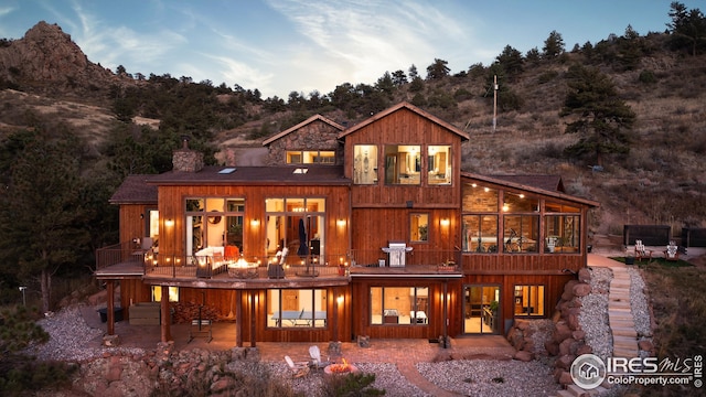 rear view of property featuring a patio and a chimney