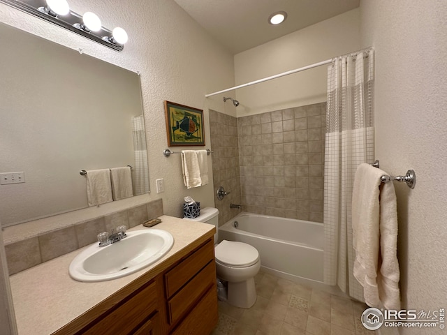 full bath featuring a textured wall, vanity, toilet, and shower / tub combo with curtain