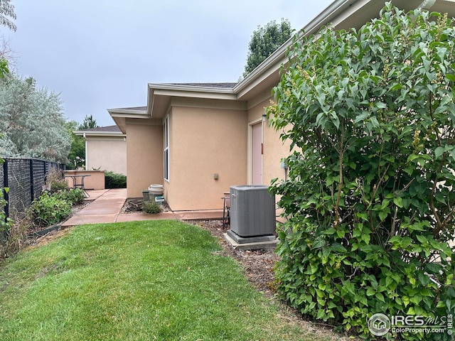 view of yard featuring fence, cooling unit, and a patio