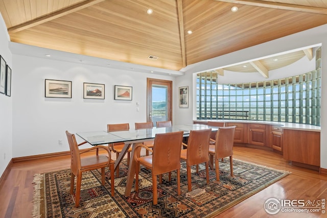 dining room featuring wood ceiling, light hardwood / wood-style flooring, and vaulted ceiling