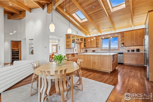 dining area with wood ceiling, dark wood-type flooring, a skylight, high vaulted ceiling, and beamed ceiling