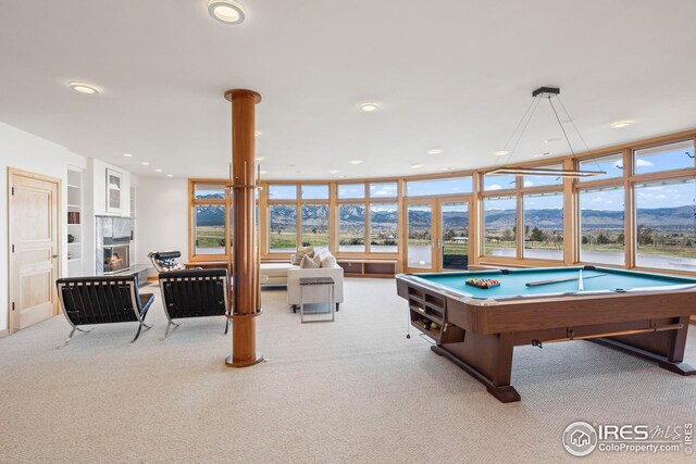 playroom with a tiled fireplace, pool table, a mountain view, and light carpet