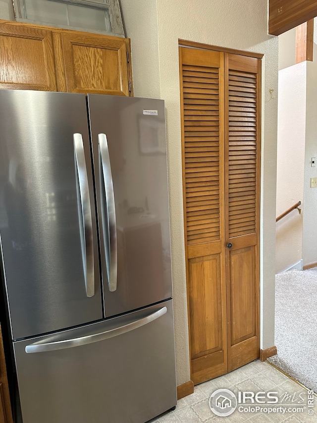 kitchen with light tile patterned flooring and stainless steel fridge