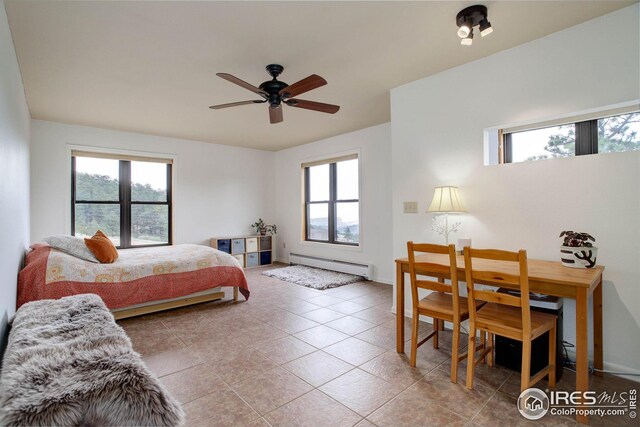 bedroom featuring light tile patterned floors, multiple windows, and baseboard heating