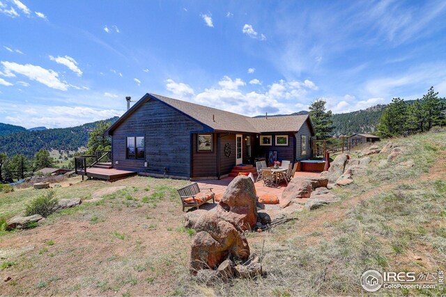 view of front facade featuring a patio and a deck with mountain view