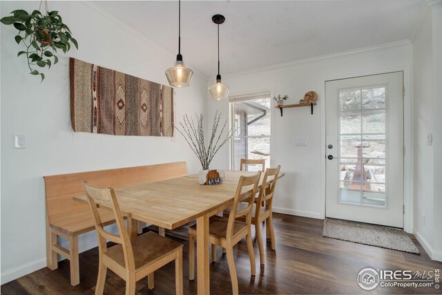 dining room with baseboards, wood finished floors, and crown molding