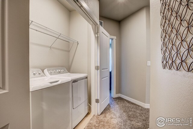 clothes washing area featuring washer and dryer and light colored carpet