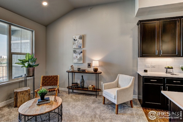 sitting room with lofted ceiling and light colored carpet