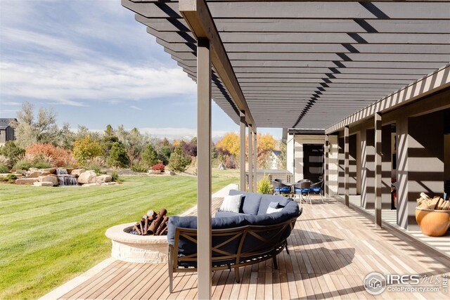 wooden terrace featuring a yard and an outdoor living space with a fire pit