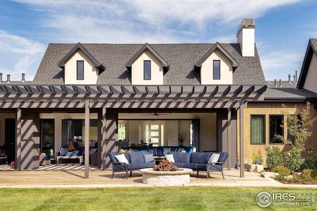 back of house featuring a deck, a lawn, a pergola, and an outdoor living space with a fire pit