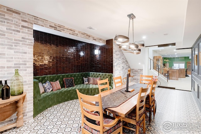 dining space featuring brick wall