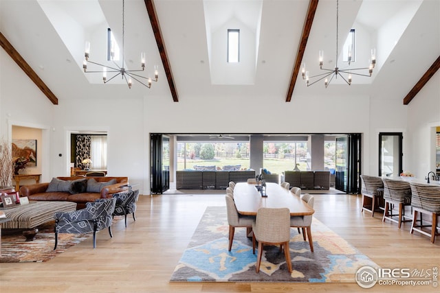 dining room with high vaulted ceiling, a wealth of natural light, and an inviting chandelier