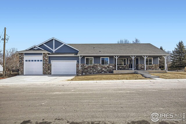 view of front of house featuring a garage, stone siding, and concrete driveway