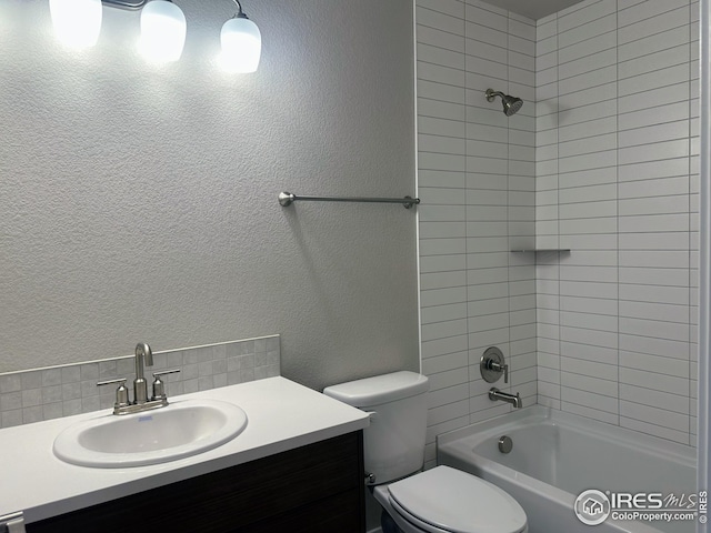 full bathroom featuring vanity, toilet, and tiled shower / bath