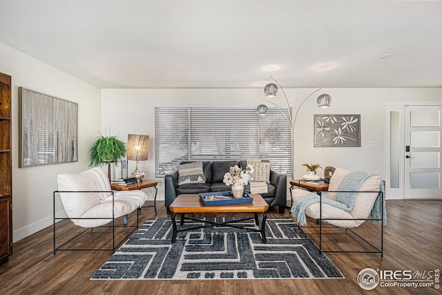 living area with baseboards and dark wood-type flooring