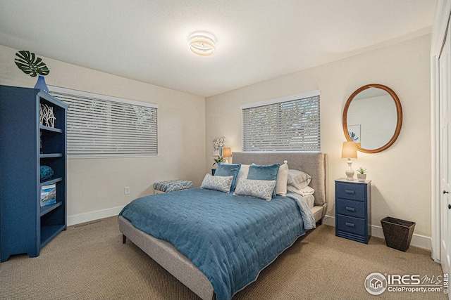 bedroom featuring light carpet and baseboards