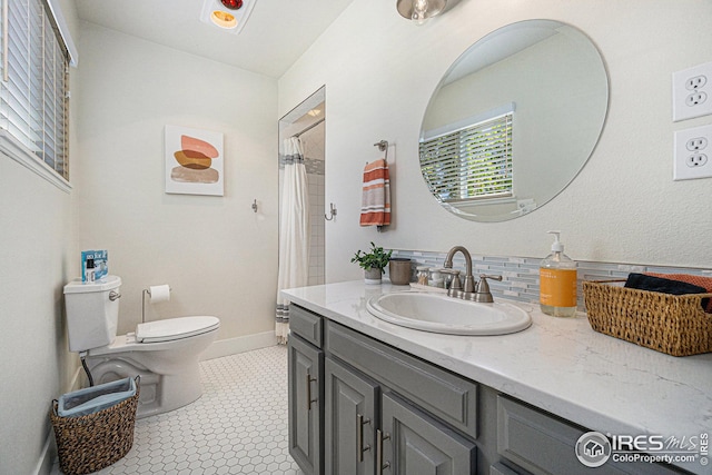 full bathroom featuring toilet, a shower with curtain, vanity, and baseboards