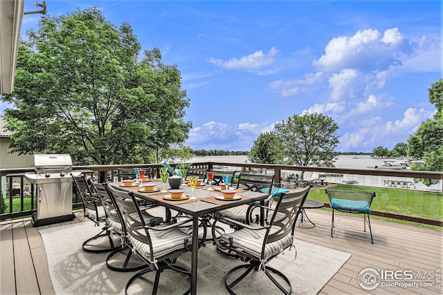 wooden terrace with outdoor dining space and a water view