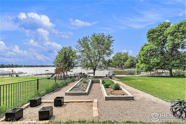 surrounding community with playground community, a water view, fence, a garden, and a yard