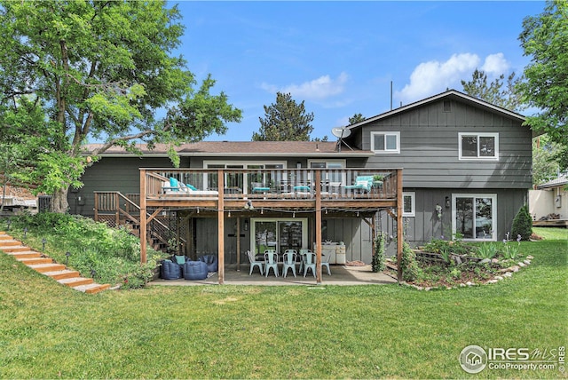 back of house with a deck, a patio area, a lawn, and stairway