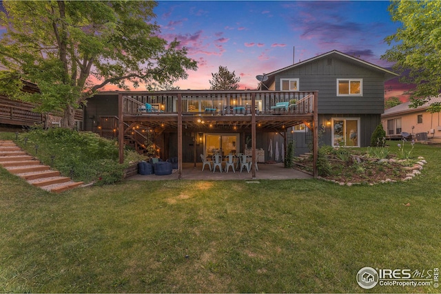 rear view of house with a deck, a yard, a patio, and stairway