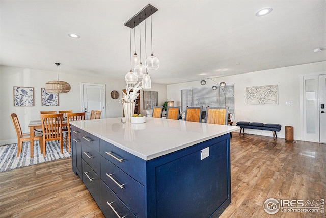 kitchen with light countertops, light wood finished floors, decorative light fixtures, and blue cabinets