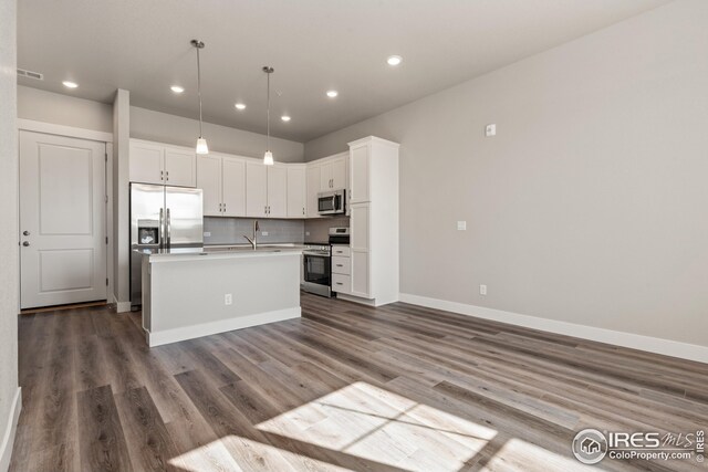 kitchen featuring dark brown cabinetry, pendant lighting, tasteful backsplash, and stainless steel appliances