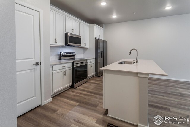 kitchen featuring sink, a kitchen island with sink, stainless steel appliances, and white cabinets