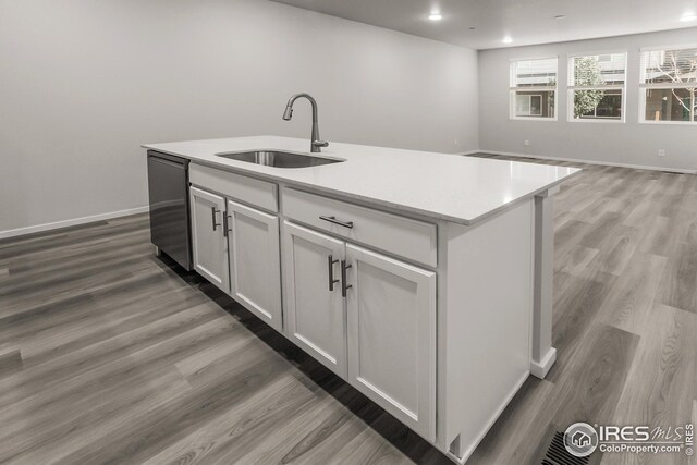 kitchen featuring white cabinets, a kitchen island with sink, stainless steel dishwasher, dark hardwood / wood-style floors, and sink