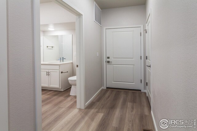 corridor featuring hardwood / wood-style flooring and sink