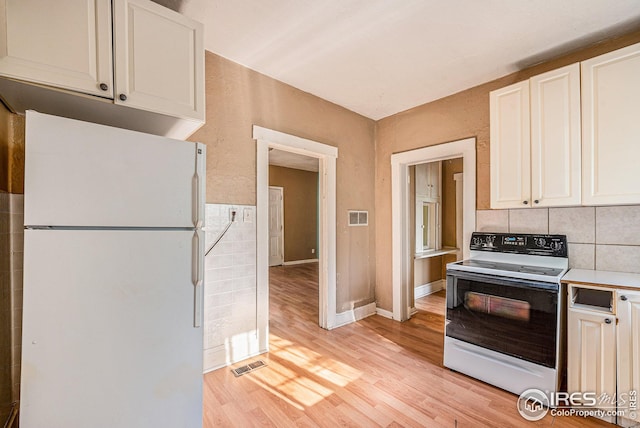 kitchen with light hardwood / wood-style flooring, white appliances, backsplash, and white cabinets