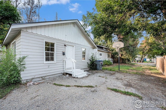 back of property with entry steps and fence