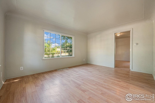 spare room featuring light wood-type flooring and visible vents