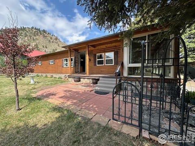 rear view of property with a lawn and a patio