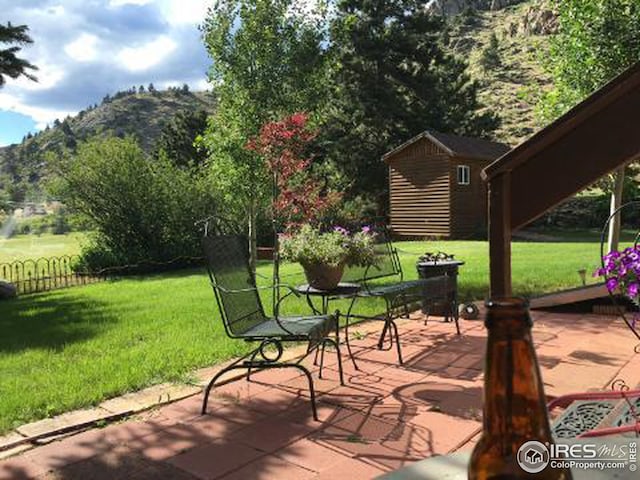 view of patio / terrace with a mountain view and a storage shed