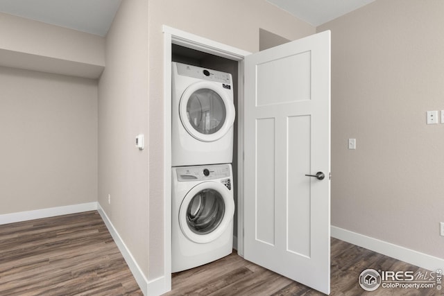 laundry area with stacked washing maching and dryer and dark hardwood / wood-style flooring