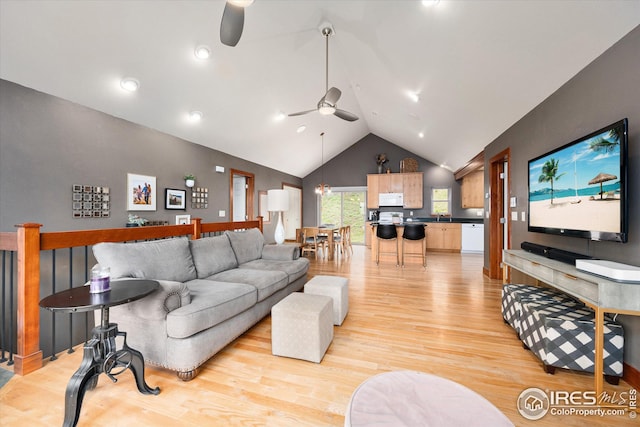 living room with vaulted ceiling, sink, light wood-type flooring, and ceiling fan