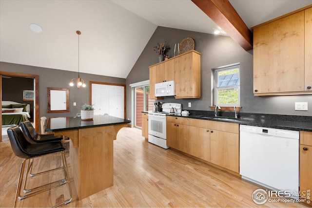 kitchen featuring a kitchen bar, light hardwood / wood-style flooring, white appliances, sink, and pendant lighting